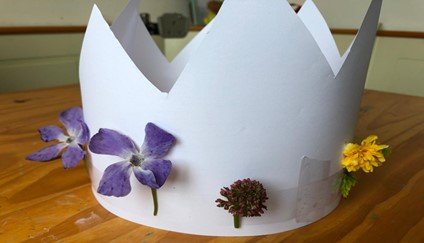 A white paper crown with purple flowers